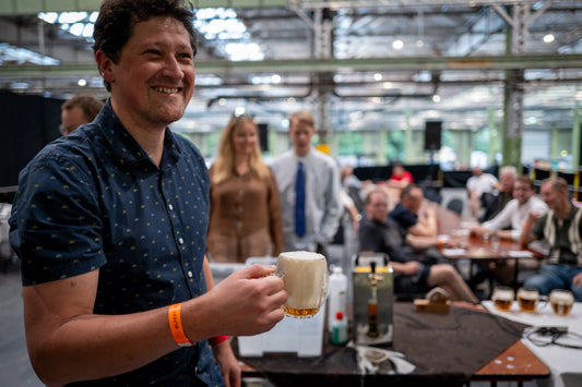 Gæst på Ølfestival 2026 holder en Mlíko skænket tjekkisk lagerøl ved Beer Bros' masterclass